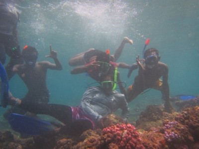A group of people pose for the camera underwater