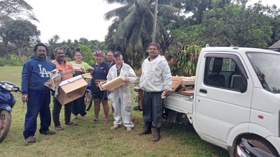 A group of people stand by a truck and smile for the camera
