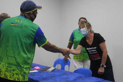 A man greets a woman with a handshake