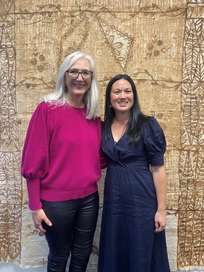 Two women standing and smiling for the camera